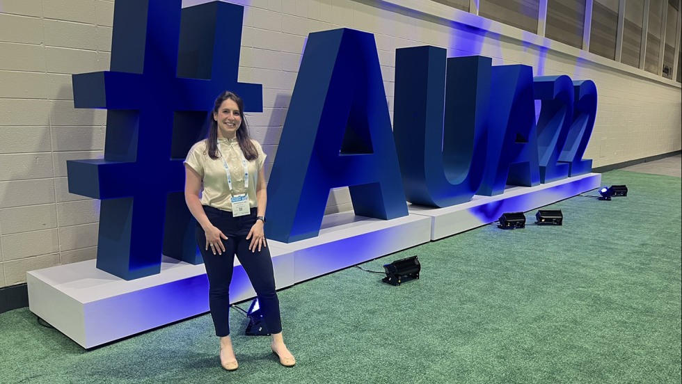 person posing near large AUA22 sign